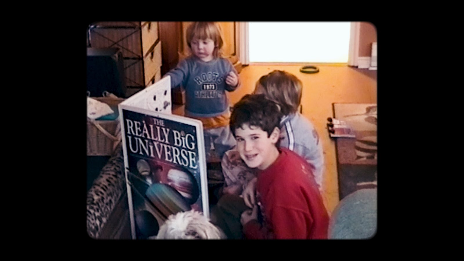 Vintage home video footage of children with a picture book